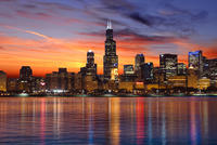 Skyscrapers in the Chicago skyline at early evening time, reflecting in the water.